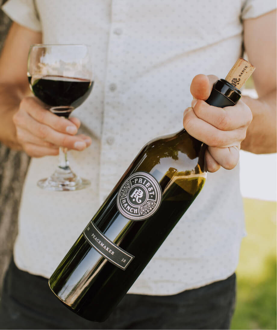 person holding wine bottle and glass